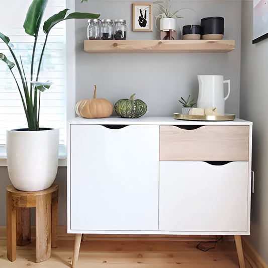 White cabinet with wooden accents in a room with a plant and decorative items.