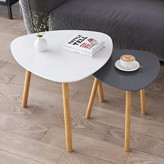 Two round side tables, one white and one gray, on a wooden floor with a cup of coffee and books.