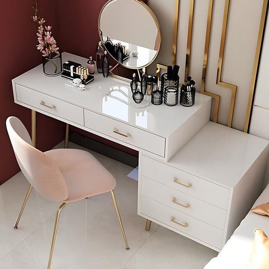 White vanity table with makeup items and a pink chair in a room.