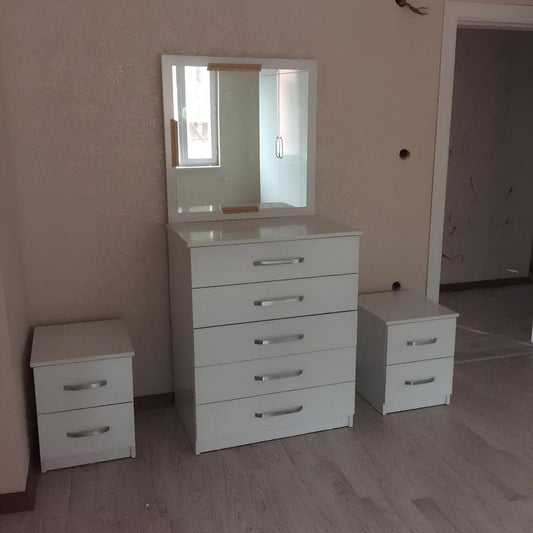 White dresser with mirror and two nightstands in a room.