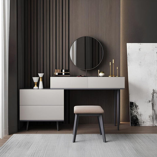 Modern vanity with round mirror, drawers, and stool against a dark paneled wall.