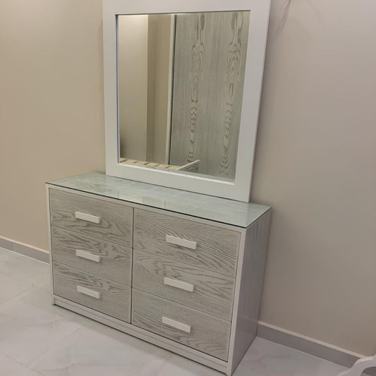 Dresser with mirror on a beige wall and tiled floor